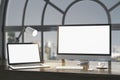 Close up of night designer desktop with empty white laptop computer screens, coffee cup and keyboard on wooden desktop and window