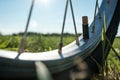 Close-up of a nipple without a cap on a bicycle wheel, in a meadow, against the background of the sky and the sun. Flat Royalty Free Stock Photo