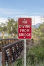 Close up of a No Diving sign beside a bridge with brown metal guardrail Royalty Free Stock Photo