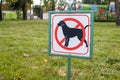 Close-up of no dog sign. Street pointer on a background of green grass. Ban on defecation and running of pets on park lawns and