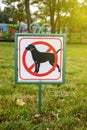 Close-up of no dog sign. Street pointer on a background of green grass. Ban on defecation and running of pets on park lawns and