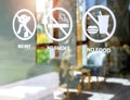 Close-up of no food and drink, pet and no smoking forbidden sign, white sticker on glass front door of cafe. Royalty Free Stock Photo