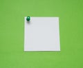 Close up of a note paper with push pin on green background Royalty Free Stock Photo