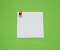 Close up of a note paper with push pin on green background Royalty Free Stock Photo