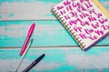 Close up of notebook with hand drawn abc alphabet letters and colorful pens on blue wooden desk background