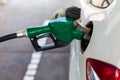 close up nozzle fuel fill oil into car tank at pump gas station