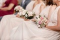 close up of nude bridesmaids dresses, flower bouquets, modern and trendy gowns sitting on wedding ceremony. wedding day Royalty Free Stock Photo