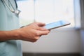 Close up of nurse or doctor entering patient information into digital tablet