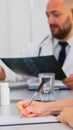 Nurse taking notes on clipboard while radiologist coworkers discussing Royalty Free Stock Photo