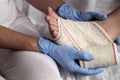 Close-up Of A Nurse Tying Bandage On Patient`s Foot