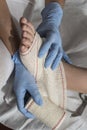 Close-up Of A Nurse Tying Bandage On Patient`s Foot