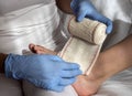 Close-up Of A Nurse Tying Bandage On Patient`s Foot