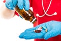 Close-up of nurse wearing red scrub spilling bottle of pills