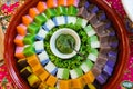 Close up of nyonya kuih (malay cakes) arranged in a beautiful circle on a decorative plate. Kuih are bite-sized dessert