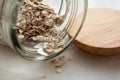 Close up of oat flakes dropped from glass jar on the table