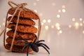 Close up of oatmeal cookies in a stack tied with brown thread and halloween black spider on bright background with bokeh. Sweet Royalty Free Stock Photo
