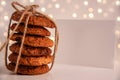 Close up of oatmeal cookies in a stack tied with brown thread and white canva mockup on bright background with bokeh. Sweet food Royalty Free Stock Photo