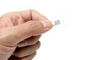 Close-up object shot of a hand holding a lighting cable isolated on a white background.