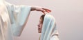 Blessing hand above the head of a woman in a headscarf