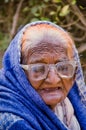 Close up of old aged poor lady bagging in front of mosque