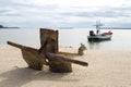 Close up of old Anchor on the beach. Small wooden fishing boat anchored on the beach Royalty Free Stock Photo