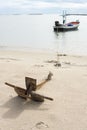 Close up of old Anchor on the beach. Small wooden fishing boat anchored on the beach Royalty Free Stock Photo