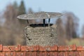 Close up of old antique dilapidated homemade brick chimney with weathered tin roof tiles , Germany