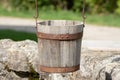 Close up of a old antique wooden bucket hanging over a well Royalty Free Stock Photo