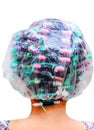 Old asian woman curling back head with plastic bag , colorful rollers and hair perm solution isolated on background Royalty Free Stock Photo