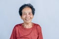 Close-up of old Asian woman face with wrinkles elderly senior and smiling happiness with a few broken teeth looking at the camera Royalty Free Stock Photo