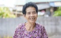 Old Asian woman face with wrinkles elderly senior. smiling happiness with a few broken teeth looking at the camera. Royalty Free Stock Photo