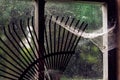 Close-up of Old Barn Window with Rake and Cobwebs Royalty Free Stock Photo