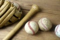 Close up old baseball, wooden baseball bat and baseball glove on a woodeb table. select focus. Royalty Free Stock Photo