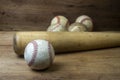 Close up old baseball and wooden baseball bat on a woodeb table. select focus. Royalty Free Stock Photo