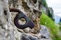 Close up of old bent piton used for mountaineering, fixed into a crack on a rock wall, part of an old climbing route, in mountains Royalty Free Stock Photo