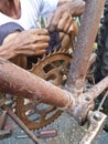 Close up of old bicycle frame and crank with hands of repairman