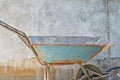 Old blue wheelbarrow on concrete blocks wall background Royalty Free Stock Photo