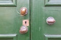 A close up of old brass door knobs on a green wooden door Royalty Free Stock Photo