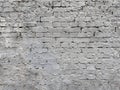 Close-up of an old brick wall painted in light gray, showing rough texture, uneven surface, and visible cracks for a rustic, Royalty Free Stock Photo