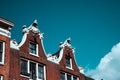 Close-up of old building facade and roof decoration against blue sky in Amsterdam. Architectonic Details Northern Netherlands