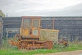 A close up of a of a old Bull dozer abandoned by a old shed