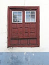 Close up of old closed vintage window. Traditional guillotine window front view. Old style red wooden window on a white cement