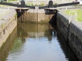 Closed wooden lock gates on the calder and hebble navigation canal in brighouse reflected in the water Royalty Free Stock Photo