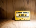 Close up of old and dirty vintage audio tape cassette in yellow plastic case Royalty Free Stock Photo