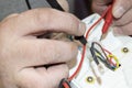 Close-up of the old electrician`s hand, the use of digital voltmeter for voltage to repair the electric iron, selective Royalty Free Stock Photo