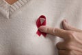 Red ribbon on breast of elderly woman closeup image Royalty Free Stock Photo