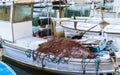 Old fisher boat with heap of fishing net on deck at harbor Royalty Free Stock Photo