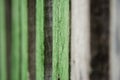 Close-up old green wooden fence with copy space. Wall of frayed wooden planks. Texture of old wooden planks with peeling paint. Royalty Free Stock Photo