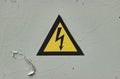 Close up of old Grey Hinged Power Supply Box with yellow danger warning sign electricity in remote places Royalty Free Stock Photo