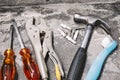 Close-up old joinery tools, Hammer, wrench, plastic anchors and drivers on dusty cement